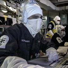 Navy personnel working on a computer in the warfare branch