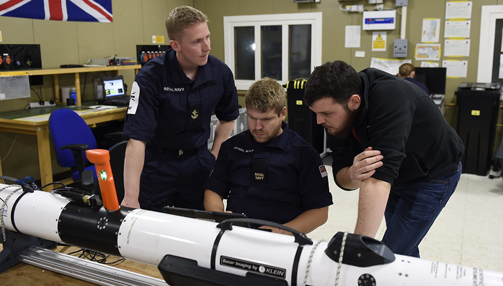 dark blue uniformed Members of the Royal Navy with unmanned underwater vehicle