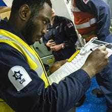 communication information systems specialist wearing high vis vest checks list