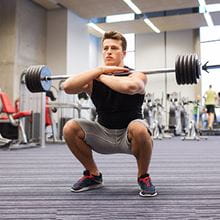 man doing squats with weights