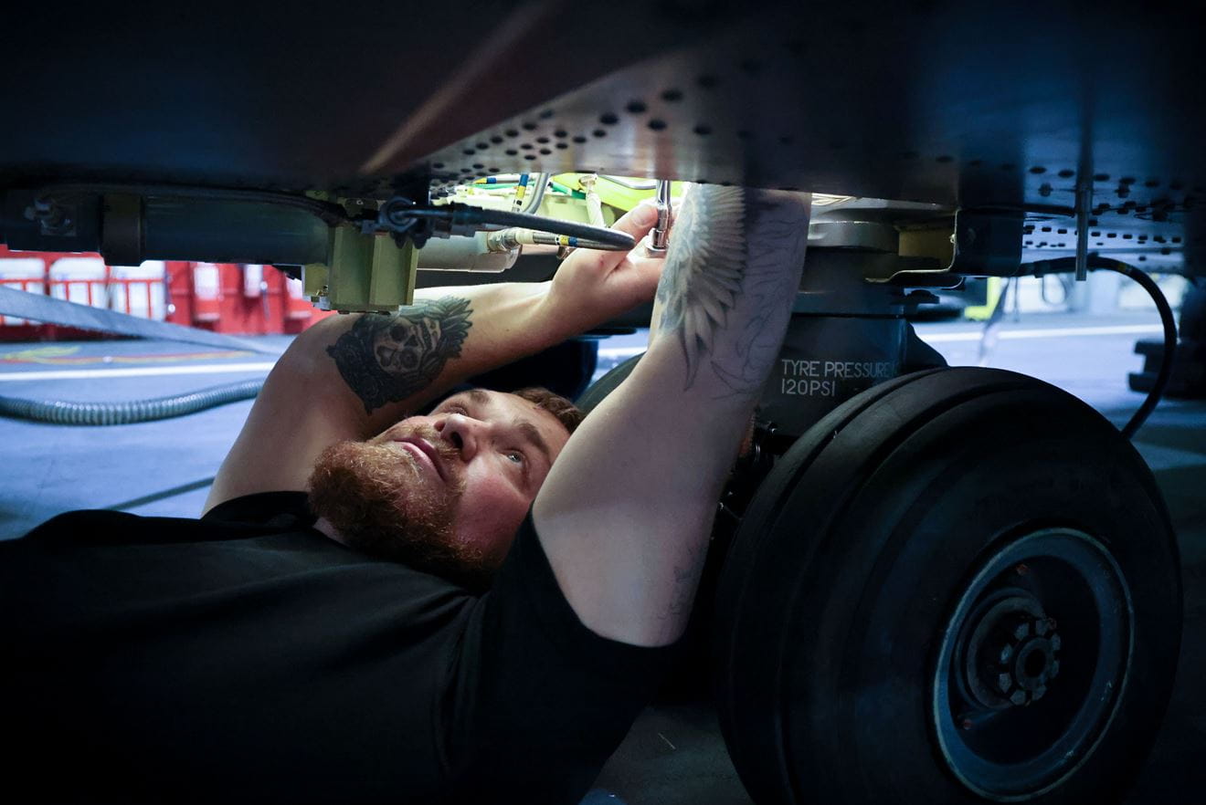 Personnel fixing the underneath of an aircraft