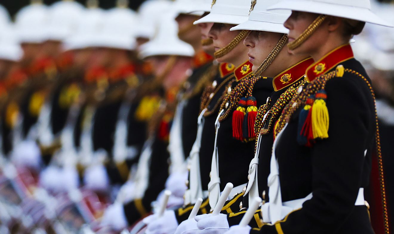 Members of the Royal Marines Band lined up playing the drums