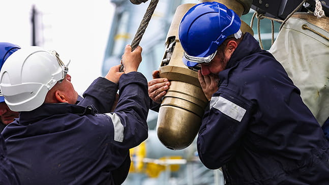 Seaman attending to equipment on deck