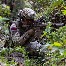 Royal marine holds weapon whilst camouflaged by plants. Photograph taken at the new RM advert being filmed in Cyprus. 