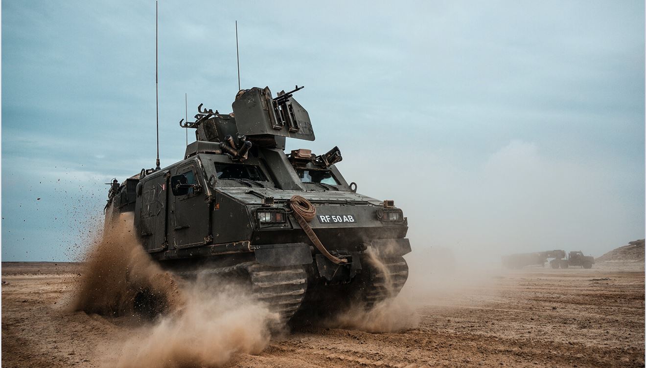 A Royal Marine vehicle travelling across some sand.