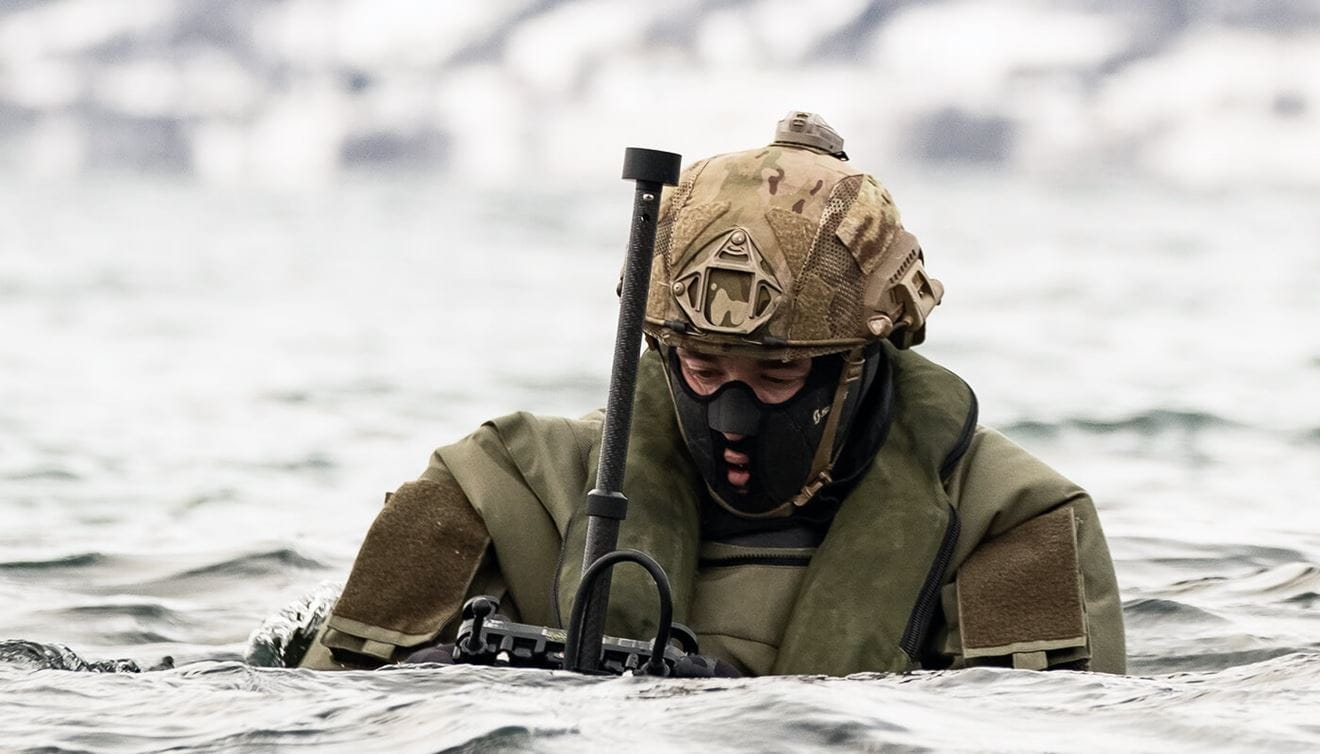 A Royal Marines floating in water carrying a remote control.