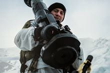 An image of a Royal Marine in uniform in the snow and holding a rocket launcher.