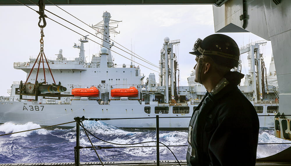 royal-navy-careers-services-06 Personnel looking at the HMS Queen Elizabeth while deployed with the UK carrier strike group, completing a transfer of live munitions.