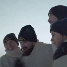 Group of submariners smiling and talking together in the arctic with hats on