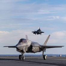 Two jets on a carrier deck during flight operations.