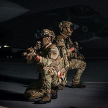 Two tactical soldiers at night, aiming their weapons.