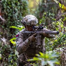 Royal-Navy-Equipment-Commando-Weaponry-08-L400-KS1-Assault-Rifle Commando in forest taking aim with an L400