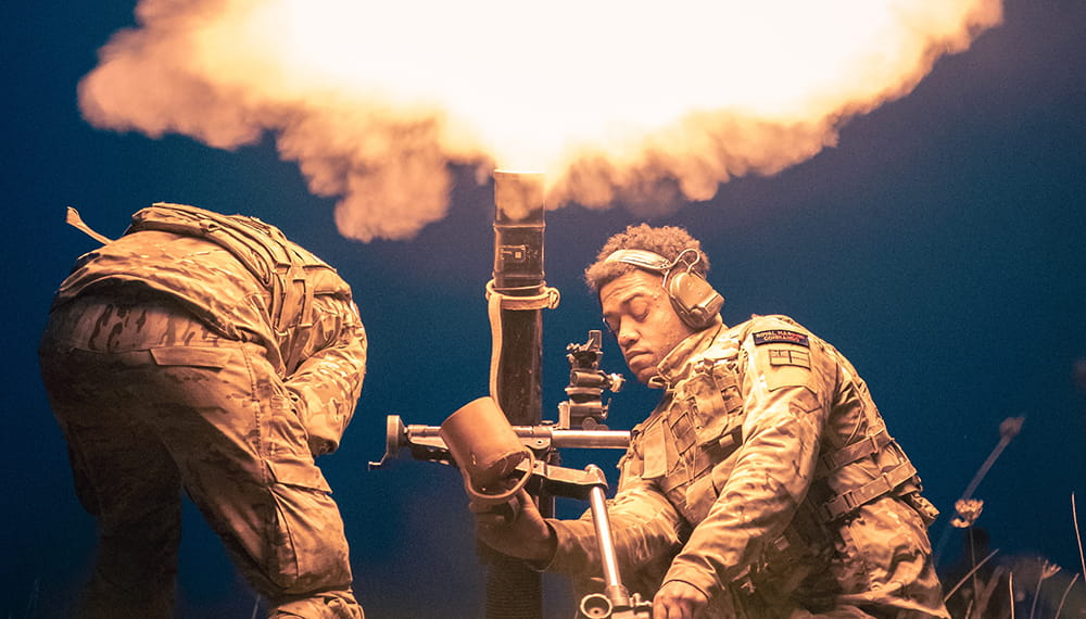 Two commandos fire mortar at night