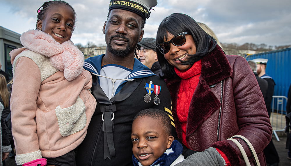 Royal-Navy-Families-and-Veterans-02-Families HMS Northumberland sailor with wife and two children smiling at camera