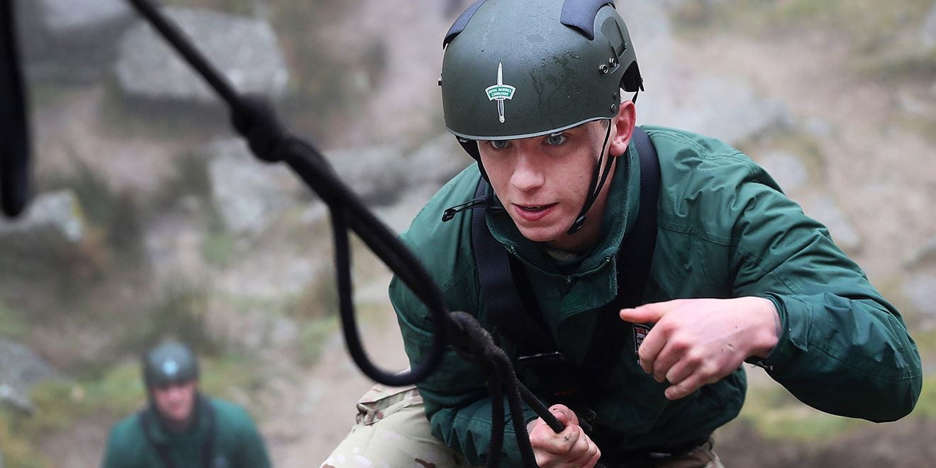 Royal-Navy-Bases-and-Stations-Lympstone-02-base Royal Marine carrying out climbing training wearing green helmet