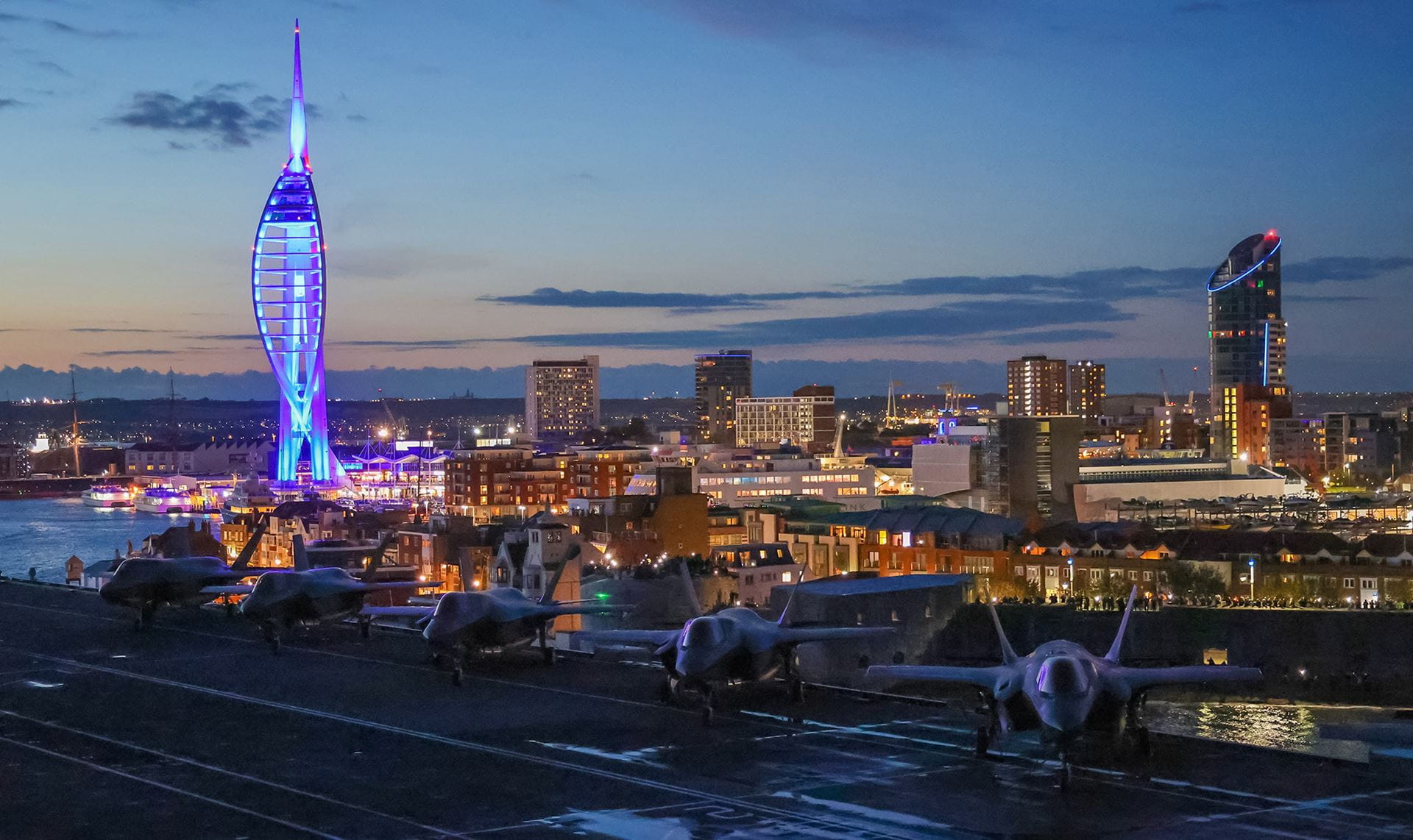 HMS Queen Elizabeth leaves Portsmouth with Spinnaker Tower in the background