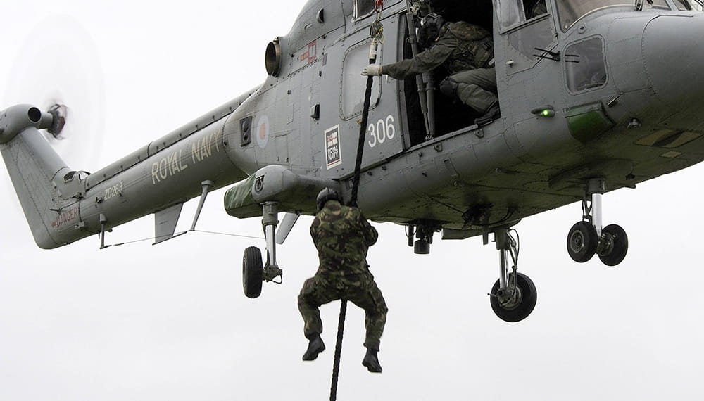 Royal-Navy-Bases-and-Stations-HMS Raleigh-04-training-school Royal Navy personnel taking part in boarding party fast rope training from a helicopter