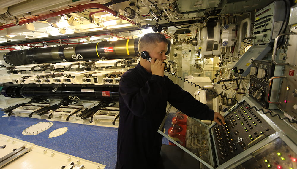 Royal-Navy-Bases-and-Stations-HMS Raleigh-05-submarine-school Man on phone in a submarine missile room operating a panel
