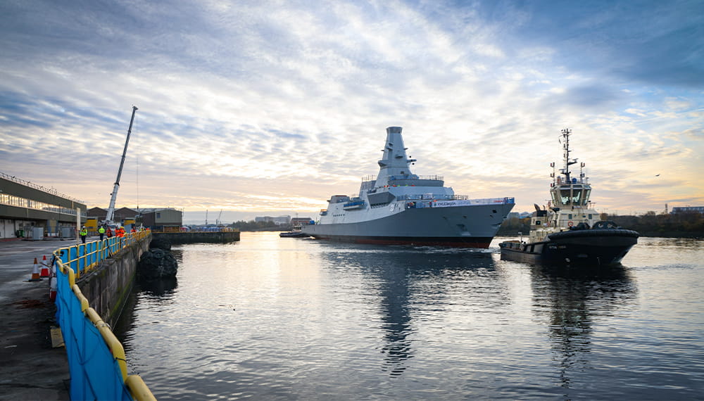 HMS Glasgow being guided by a patrol boats through the port of Clyde