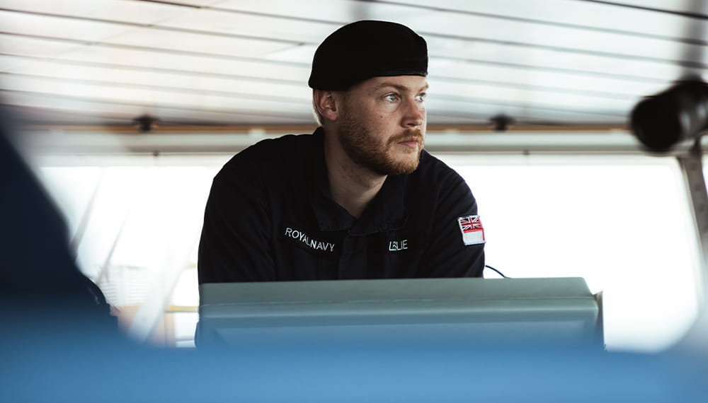 A navy sailor with a baret giving a speech at a podium
