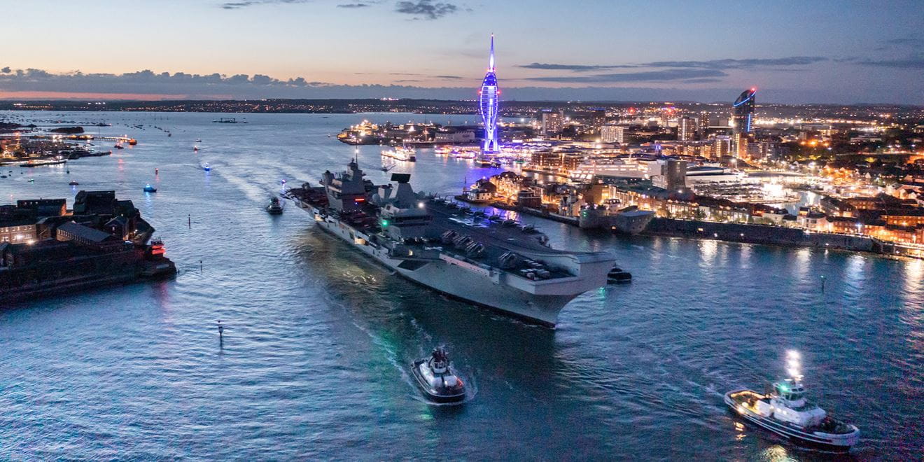 Queen Elizabeth carrier approaching harbour at dusk