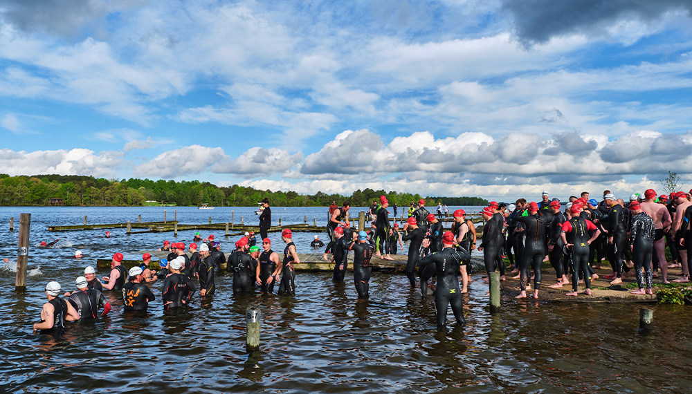 A lot of swimmer standing on shore prepare for a race
