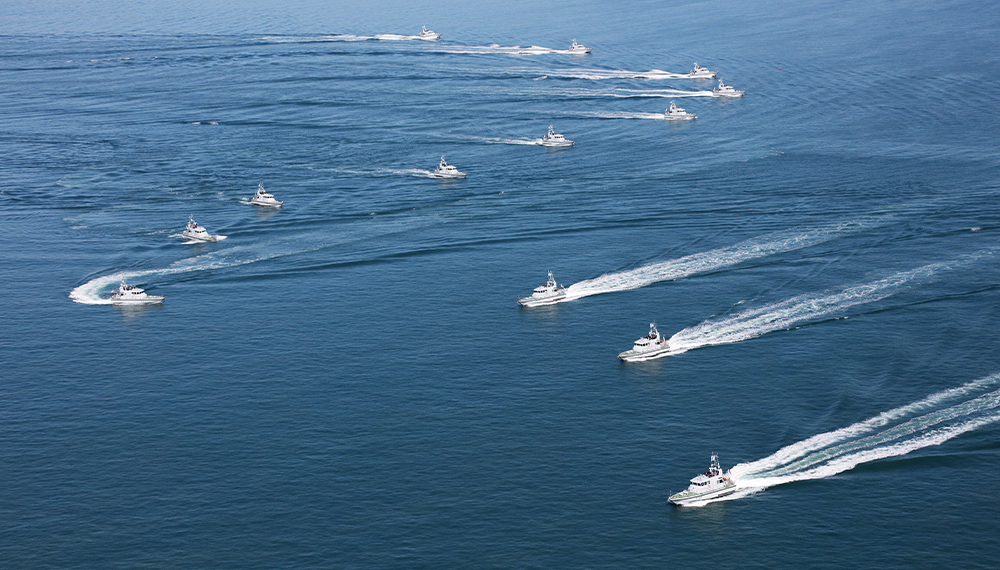 Context image of a fleet of boats on maneuver at sea