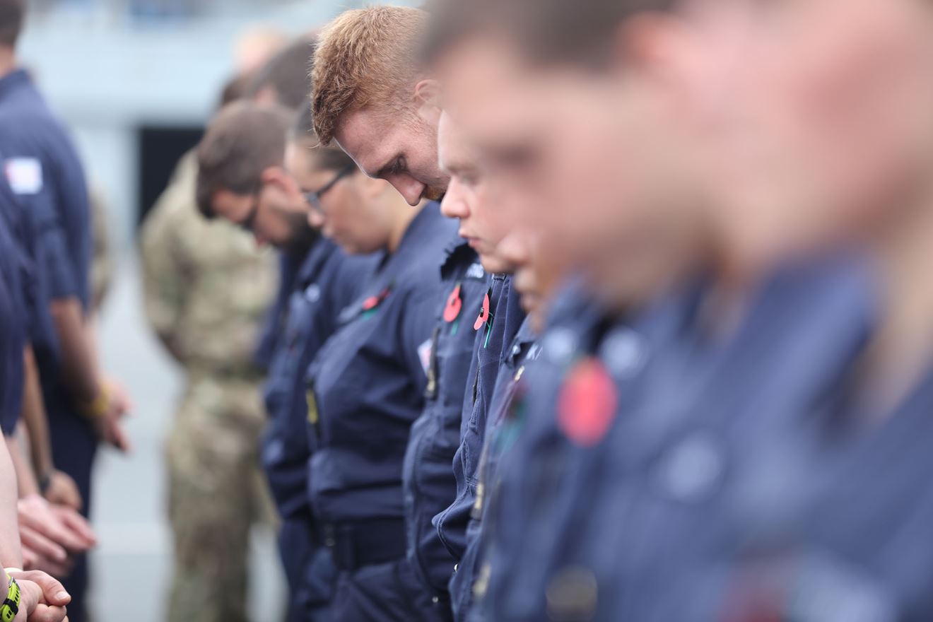Sailors, soldiers and Royal Marines bow in reverence on RFA Argus
