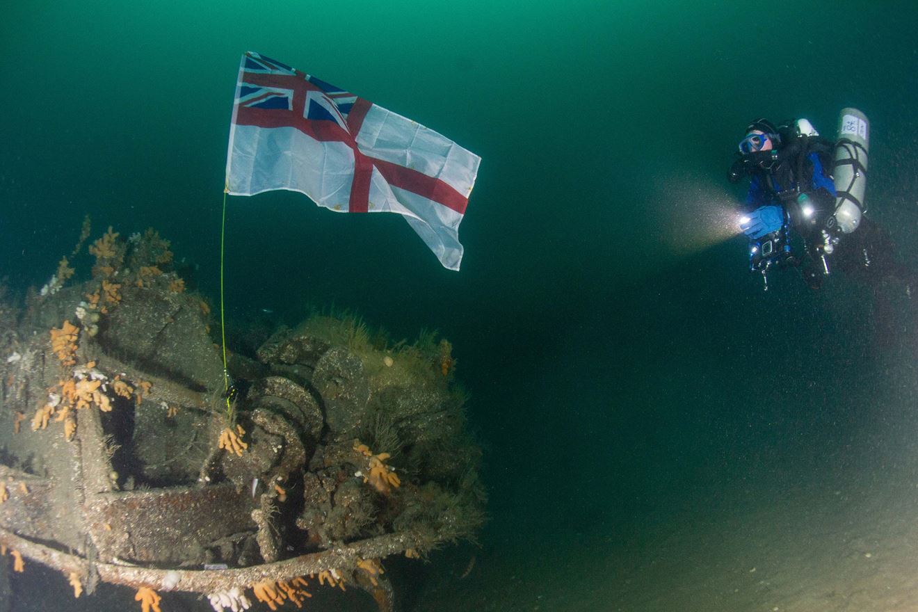 Lt Cdr Jen Smith shines a light on the Ensign on HMS Exmouth