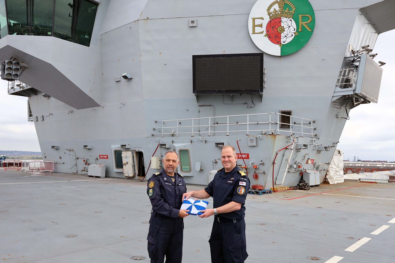 Italys Rear Admiral Andrea Petroni receives the task group standard from Rear Adm Rob Pedre