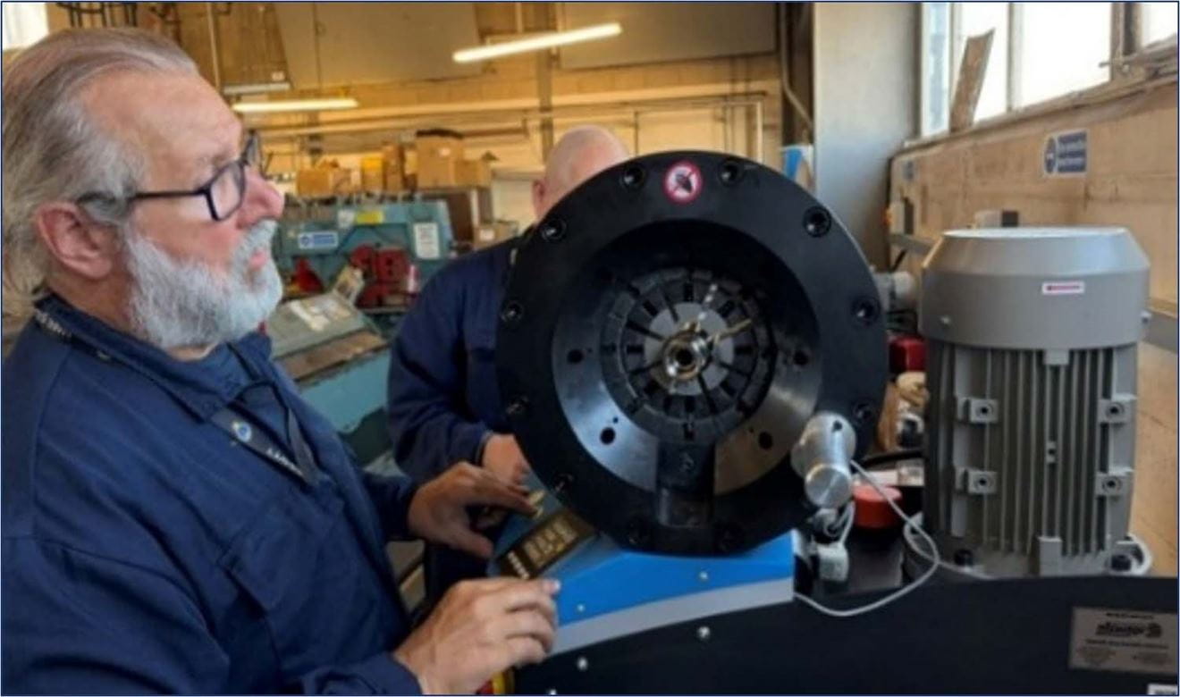 A Royal Navy engineer assembles a flexible hose