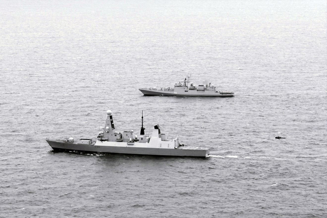 HMS Defender, nearest the camera, with Indian guided-missile frigate Tarkash in the Channel, Aug 14 2019, during Exercise Konkan. An Indian Helix helicopter can be seen approaching Defender's flight deck