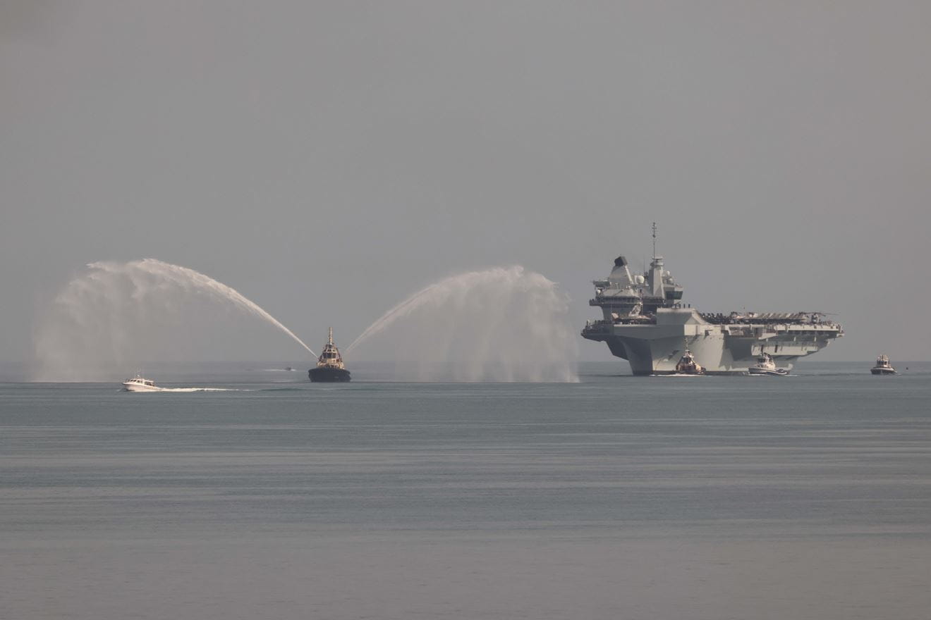 HMS Prince of Wales enters the port of Darwin and HMAS Connawarra.