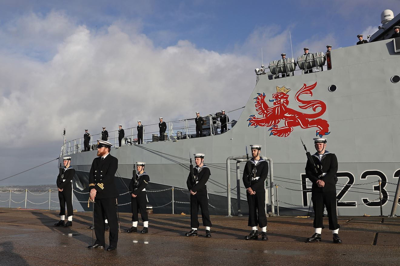 Under Tamar's giant lion motif the Guard of Honour stands at ease on a wet jetty