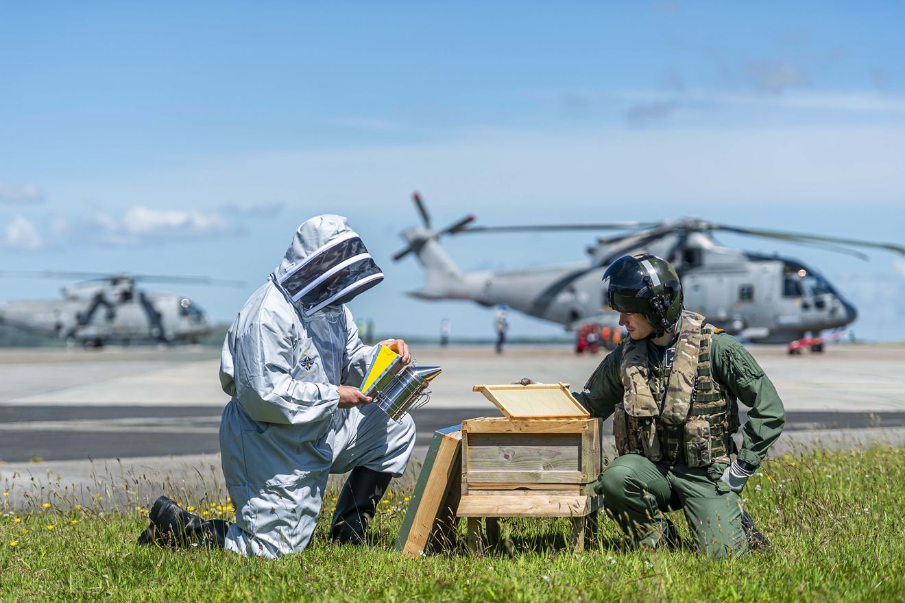 Survival Equipment Technician James Harrison (left) and Lieutenant Adam Pollock (right) inspect the beekeeping equipment.