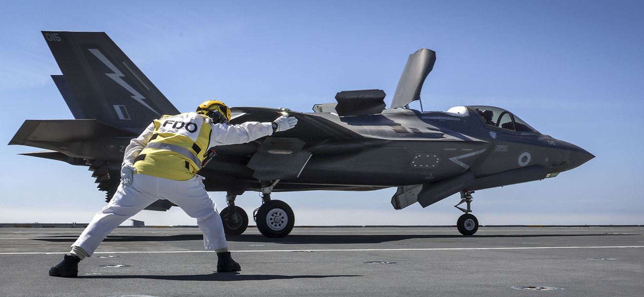 The Flight Deck Officer onboard HMS Prince Of Wales launches the ships first ever F35 flown by Pilot Ben of the Royal Navy.