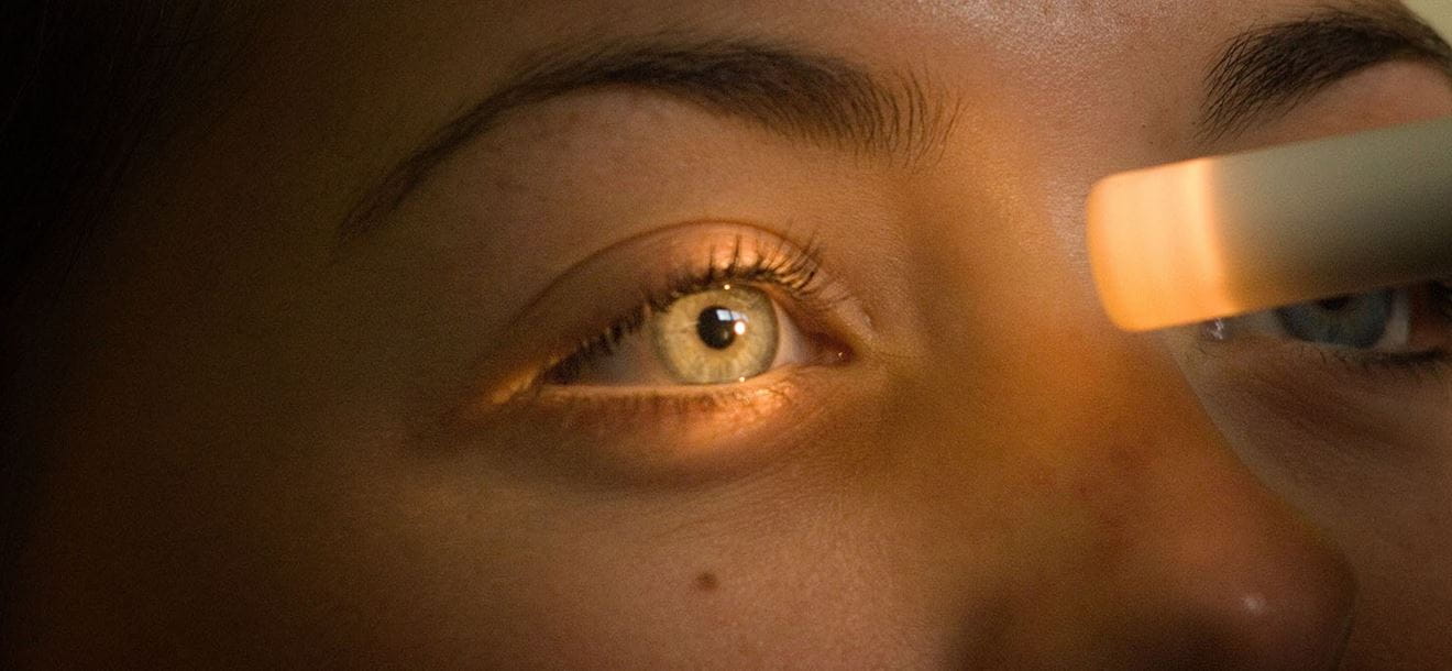 Close up of light shining into eye as eye test is being carried out