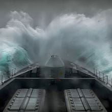 A wave crashes over the ship