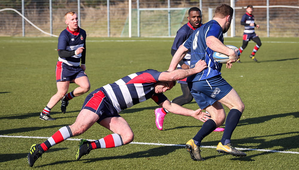 Royal-Navy-Our-People-Duty-and-Commitment-03-healthy.jpg One man attempts to tackle another in a rugby match
