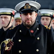 Royal-Navy-Our-People-Leadership-06-leading-others.jpg Royal Navy officer stands with a sword on his shoulder