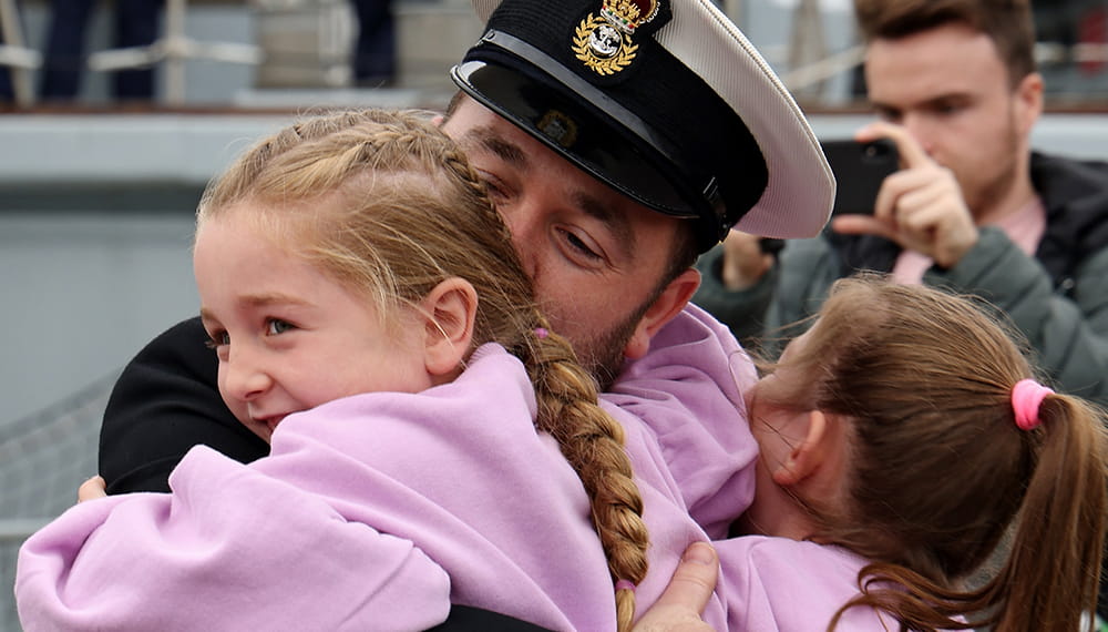 Royal-Navy-Our-People-Ops-for-all-06-families.jpg Royal Navy Lieutenant hugs his two daughters