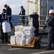 Royal-Navy-Our-People-Our-Values-18-cost-effectiveness.jpg RFA sailors unloading several large white bags of narcotics
