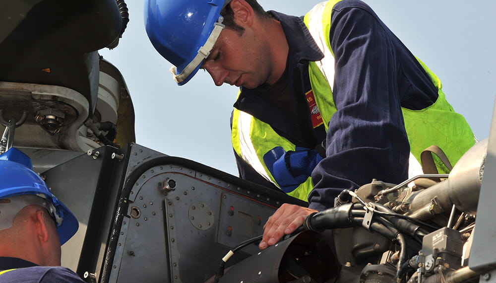 Two Royal Navy engineers work on machinery