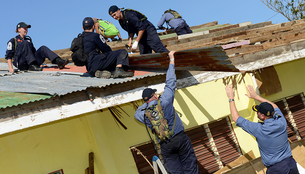 Royal-Navy-What-we-do-Respond-04-restoring-infrastructure.jpg Royal Navy sailors fix a corrugated iron roof