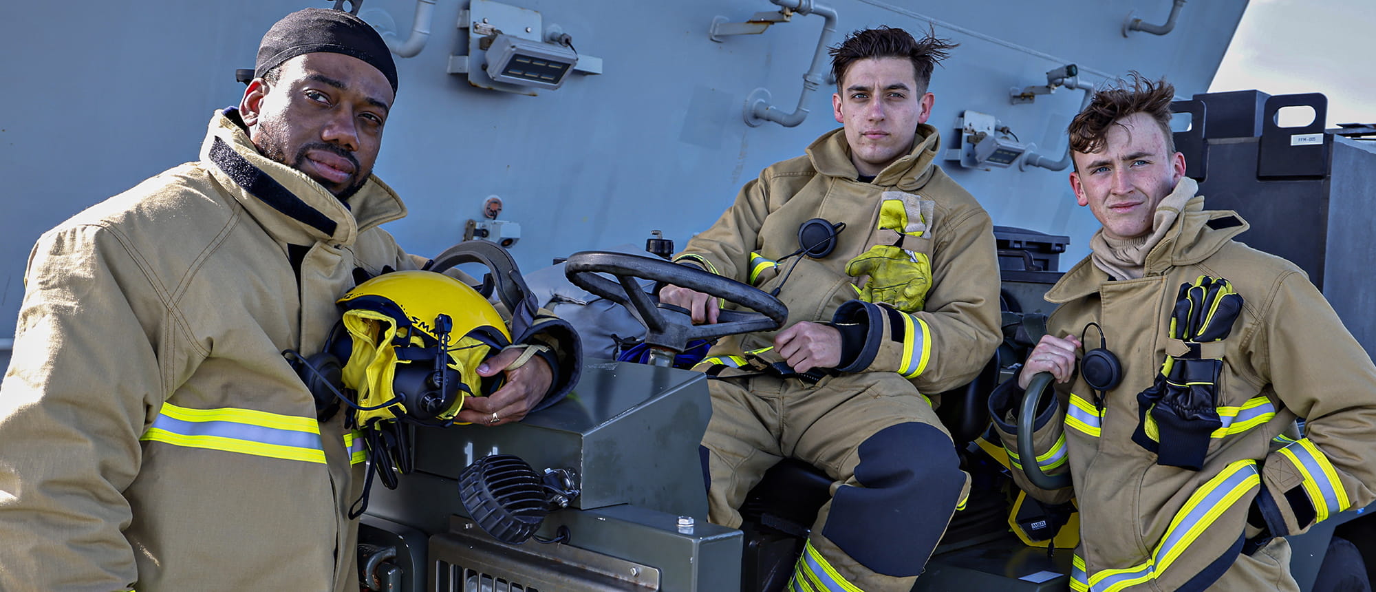 flight deck handlers dressed in ochre kit with high viz banding relaxing after a busy session on the flight deck of HMS Prince Of Wales