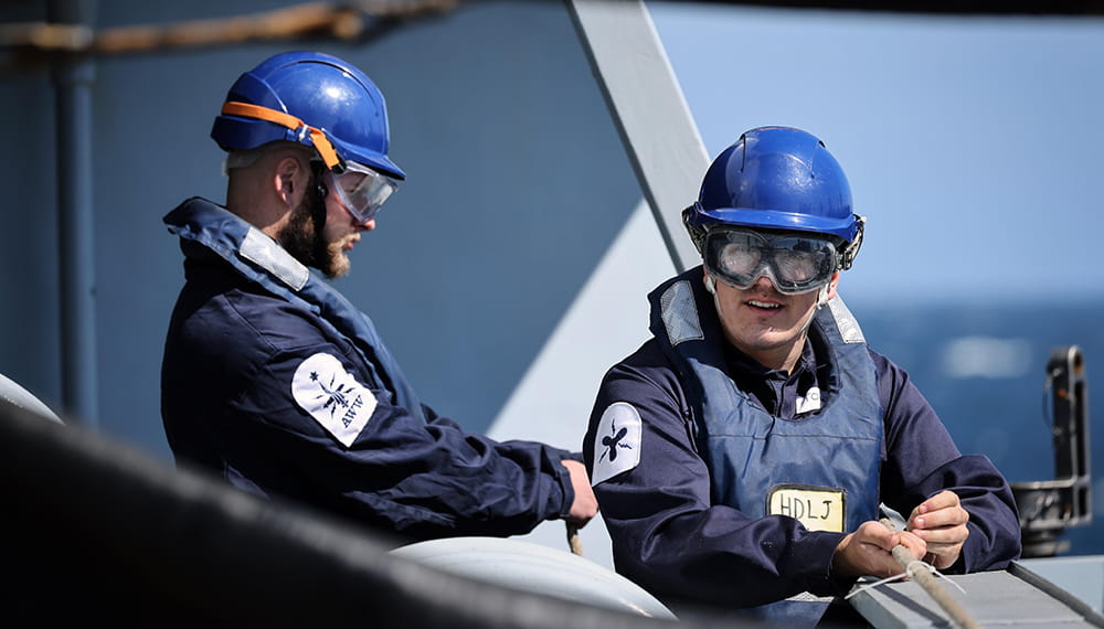 Royal Navy sailors on board HMS Defender during a replenishment at sea with USNS Patuxent.