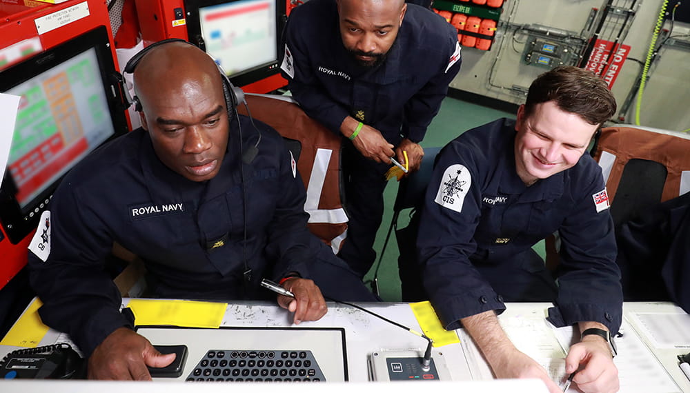 royal-navy-careers-joining-options-02 three uniformed royal navy personnel looking at computer screen