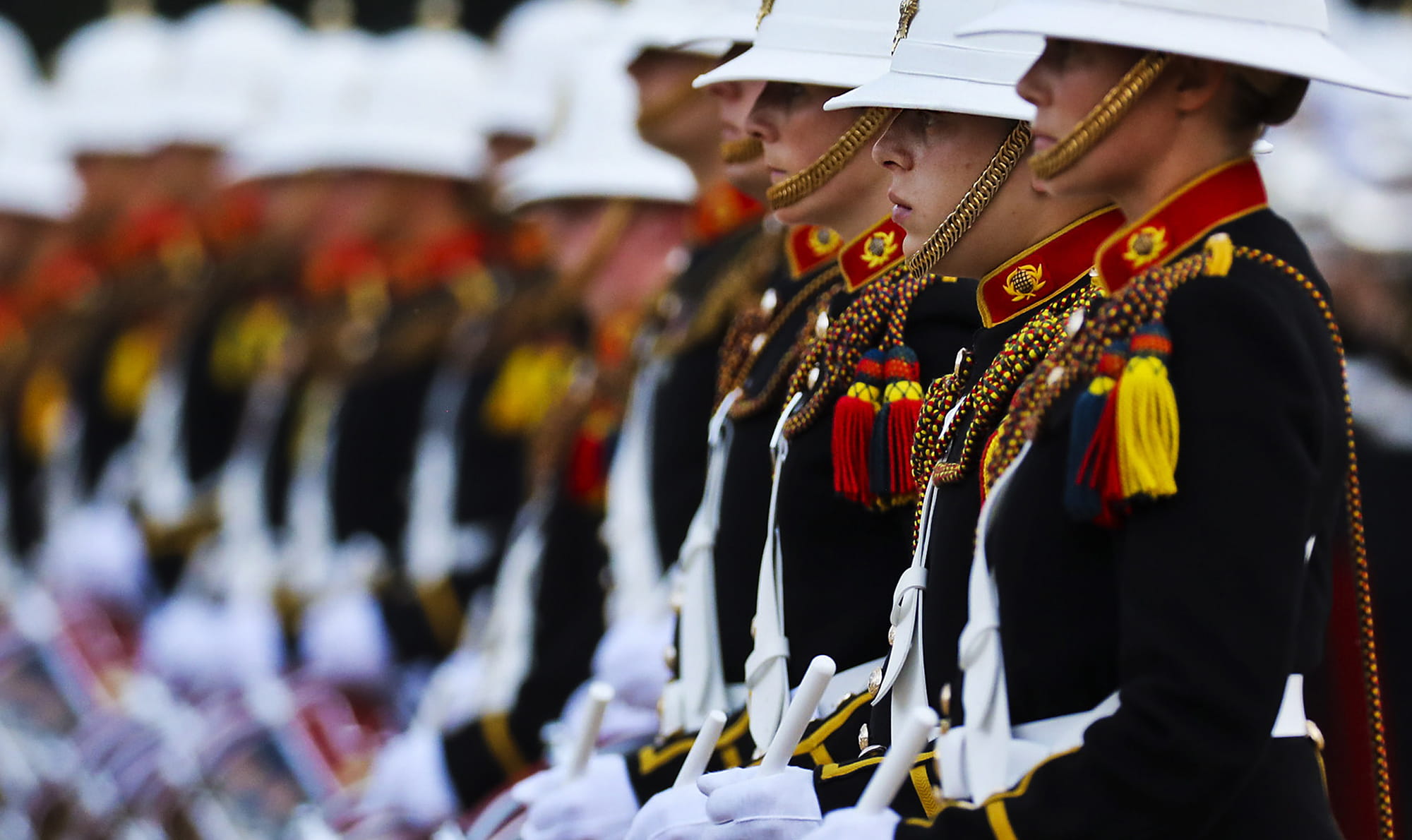 Members of the Royal Marines Band lined up playing the drums