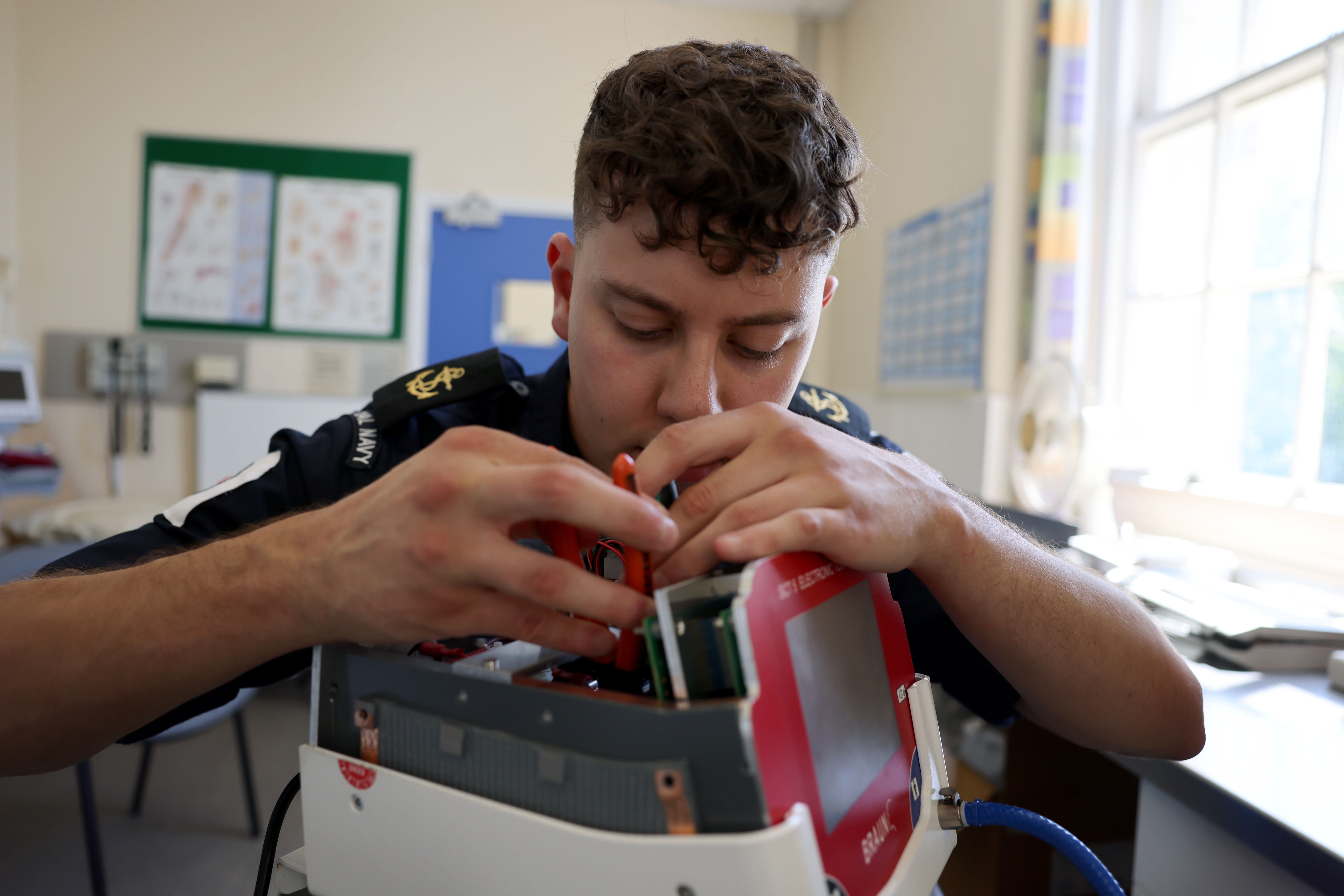 Royal Navy personnel fixing medical equipment