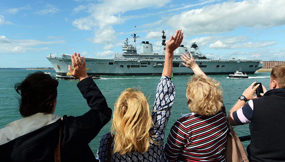 Royal-Navy-Families-06-Royal-Navy-Forum_1 Friends and family wave towards a Royal Navy ship from the coast
